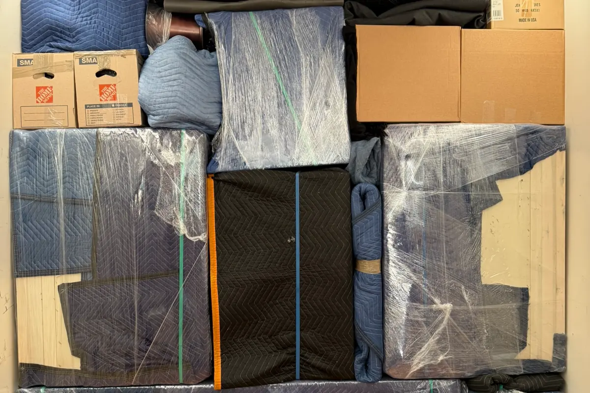 Inside a Trinity Movers truck packed wall to wall with blanket-wrapped and shrink-wrapped furniture